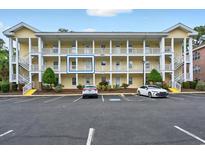 Attractive multi-story condo building with ample parking spaces and well-kept landscaping and inviting stairwells at 4251 Hibiscus Dr. # 202, Little River, SC 29566