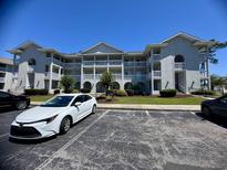 Condo building with white trim, balconies, landscaping and parking at 4430 Eastport Blvd. # L-11, Little River, SC 29566