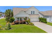 Charming two-story home featuring a well-manicured lawn and an attached two-car garage at 450 Oaklanding Ln., Murrells Inlet, SC 29576