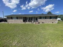 Charming brick ranch home with a well-manicured lawn and inviting curb appeal on a sunny day at 4637 Dogwood St., Loris, SC 29569