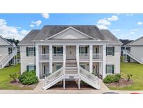 Inviting exterior view of a two-story condo with white railings and green shutters at 4924 Pond Shoals Ct. # 201, Myrtle Beach, SC 29579