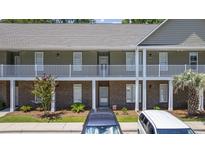 Inviting two-story condo building with brick and siding, complemented by well-maintained landscaping at 50 Turning Stone Blvd. # 7, Murrells Inlet, SC 29576
