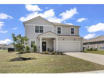 Charming two-story home with a well-manicured lawn and attached two car garage at 5001 Sweet Birch Lane, Conway, SC 29526