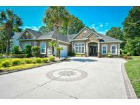 Stately home with stone accents, well-manicured landscaping, and a circular driveway at 5718 Herring Gull Circle, North Myrtle Beach, SC 29582
