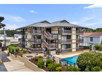 Multi-level condo with balconies, dark wood trim and siding, and a pool at 6813 Porcher Dr. # 25, Myrtle Beach, SC 29572