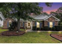 Charming brick home with blue shutters, manicured landscaping, and a welcoming front entrance at 7007 Blade Beak Ln., Myrtle Beach, SC 29588