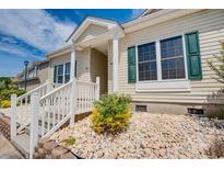 Charming home featuring a quaint front porch with stone landscaping and vibrant green shutters at 702 Beach Walk Pl. # 702, Myrtle Beach, SC 29577