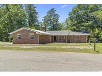 Charming brick ranch home with a metal roof and well-maintained front yard at 1043 South Main St., Aynor, SC 29511