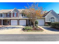 Charming townhouse featuring a one-car garage, manicured landscaping, and neutral siding, radiating curb appeal at 107 Pawleys Place Dr. # 107, Pawleys Island, SC 29585