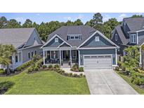 Charming blue two-story home with a well-manicured lawn and an attached two-car garage at 1131 East Isle Of Palms, Myrtle Beach, SC 29579