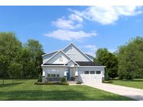 Charming two-story home with a well-manicured lawn and attached two-car garage at 1416 Whistling Straits Way, Sunset Beach, NC 28468