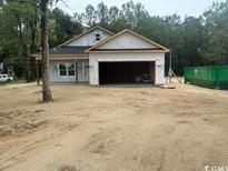 New home construction with an attached two-car garage in a partially wooded area at 146 Temple Dr., Aynor, SC 29511
