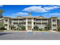 Inviting condo exterior showcasing ample parking, landscaping, and multiple covered balconies at 1551 Spinnaker Dr. # 5913, North Myrtle Beach, SC 29582