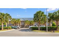 Inviting condo exterior with palm trees, parking, and a well-maintained brick facade under a sunny sky at 210 Double Eagle Dr. # B-2, Surfside Beach, SC 29575