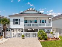 Charming raised beach house with white siding, gray shutters, and a spacious front porch at 2405 Duffy St., North Myrtle Beach, SC 29582
