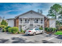 Inviting two-story condo featuring white siding and a charming exterior staircase and landscaping at 251 Egret Run Ln. # 1122, Pawleys Island, SC 29585
