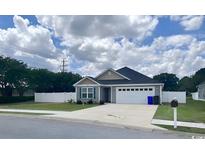 Single-Gathering home with gray siding, a two-car garage, and a well-manicured lawn at 2599 Woodcreek Ln., Conway, SC 29527