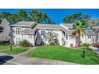 Inviting exterior of a two-story condo featuring lush landscaping and a well-maintained lawn at 4486 Little River Inn Ln. # 2106, Little River, SC 29566