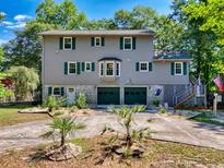 Two-story home featuring a two-car garage, grey siding, green shutters, and neatly landscaped yard at 515 River Rd., Conway, SC 29526