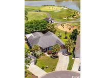 Beautiful home overlooking a lush golf course and tranquil lake, showcasing the property's prime location and scenic views at 7005 Wellesley Ct., Murrells Inlet, SC 29576