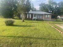 Charming single-story home with a well-maintained lawn and mature trees in a suburban neighborhood at 704 W Alder St., Andrews, SC 29510