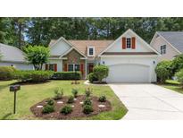 Charming single-Gathering home featuring a stone accent wall, red shutters, well-manicured lawn and two-car garage at 77 Redwing Ct., Pawleys Island, SC 29585