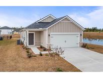 Charming single-Gathering home featuring a two-car garage, well-maintained lawn and quaint landscaping at 8253 Vibrant Loop, Longs, SC 29568