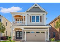 Charming two-story home featuring a front porch, a two car garage, and stylish architectural details at 873 Crystal Water Way, Myrtle Beach, SC 29579