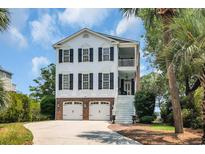Charming two-story home with brick accents, double garage, and a welcoming staircase leading to a cozy balcony at 92 High Hammock Way, Pawleys Island, SC 29585