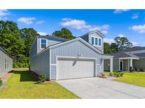 Charming two-story home featuring a light blue exterior, attached garage, and well-manicured lawn at 1008 Sentinel Ct., Little River, SC 29566