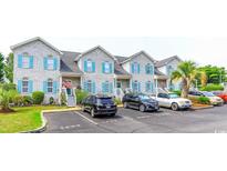 Charming townhouse exterior with white brick facade, colorful shutters, and convenient parking at 1437 Baldwin Ct. # 1437, Little River, SC 29566
