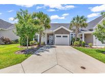 Charming home with an attached garage and a well-manicured lawn with mature trees and a long concrete driveway at 232 Je Edward Dr. # 19, Myrtle Beach, SC 29588