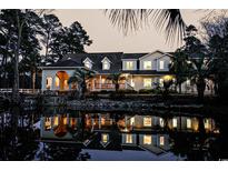 Stunning exterior view with water reflection, mature trees, and a charming facade, creating a serene and inviting atmosphere at 2790 Fowler Rd., Loris, SC 29569
