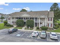 Inviting two-story condo with white staircases and red shutters in a well-maintained complex at 3676 Clay Pond Village Ln. # 4, Myrtle Beach, SC 29579