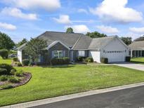 Charming single-story home featuring a well-manicured lawn, brick accents, and an attached two-car garage at 4012 Grousewood Dr., Myrtle Beach, SC 29588