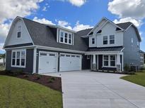 Charming two-story home with a two-car garage, gray siding, and white trim, under a bright blue sky with fluffy clouds at 419 Starlit Way, Myrtle Beach, SC 29579