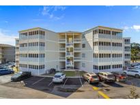 Multi-story condo building with beachside vibe, showcasing multiple units with screened-in porches and ample parking at 4350 Intercoastal Dr. # 2408, Little River, SC 29566