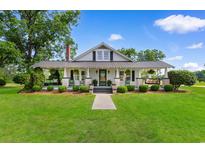 Charming single-story home featuring a large front porch with swing and well-manicured lawn at 4499 Highway 308, Aynor, SC 29544