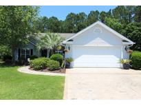 Charming home featuring a well-manicured lawn, lush landscaping, and a two-car garage at 513 Westham Dr., Murrells Inlet, SC 29576