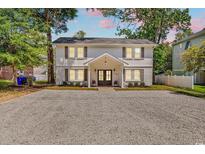 Charming two-story home with a gravel drive and welcoming entrance at 514 6Th Ave. S, Surfside Beach, SC 29575