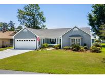 Charming single-story home with a well-manicured lawn, attached garage, and welcoming front porch at 578 Circle Dr., Myrtle Beach, SC 29575