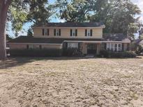 Traditional two-story home featuring a symmetrical facade, classic shutters, and a landscaped front yard with mature trees at 903 23Rd Ave. N, North Myrtle Beach, SC 29582