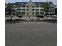 A three-story condo building featuring outdoor patios and a parking lot at 102 Scotch Broom Dr. # B-202, Little River, NC 29566