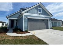 Charming home featuring hardiplank siding, a grey garage door, and a well-manicured lawn at 1232 Lady Bird Way, North Myrtle Beach, SC 29582