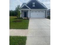 Charming single-story home featuring a manicured lawn, two-car garage and covered porch at 1305 Wykham Park Dr., Myrtle Beach, SC 29579