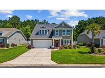 Charming two-story home featuring a well-maintained lawn, two car garage, and inviting front porch at 284 Whipple Run, Myrtle Beach, SC 29588
