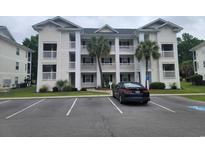 Attractive condo building featuring multi-story units and mature palm trees in a parking lot setting at 477 White River Dr. # 32-H, Myrtle Beach, SC 29579