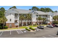 Spacious condo featuring covered balconies, palm trees, brick accents, and ample parking in a convenient location at 6015 Catalina Dr. # 534, North Myrtle Beach, SC 29582