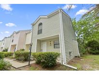Charming two-story townhouse featuring light green siding, manicured bushes, and a well-maintained lawn on a sunny day at 6703 Jefferson Pl. # B7, Myrtle Beach, SC 29572