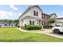 Charming two-story townhome with a manicured lawn and lovely red shutters, perfect for comfortable living at 8855 Radcliff Dr. Nw # 53C, Calabash, NC 28467